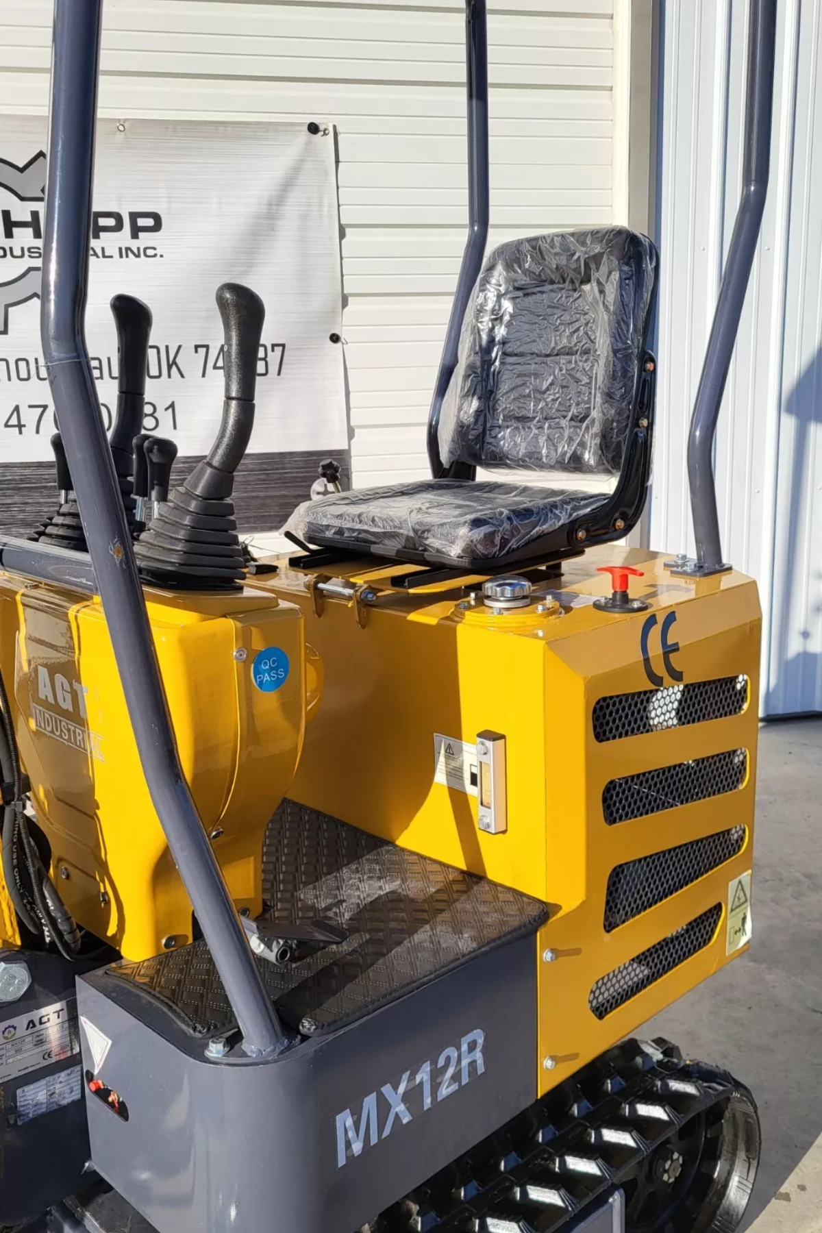 AGT MX12R mini excavator operator station: wrapped seat, hand levers, hydraulic tank cap and red battery switch