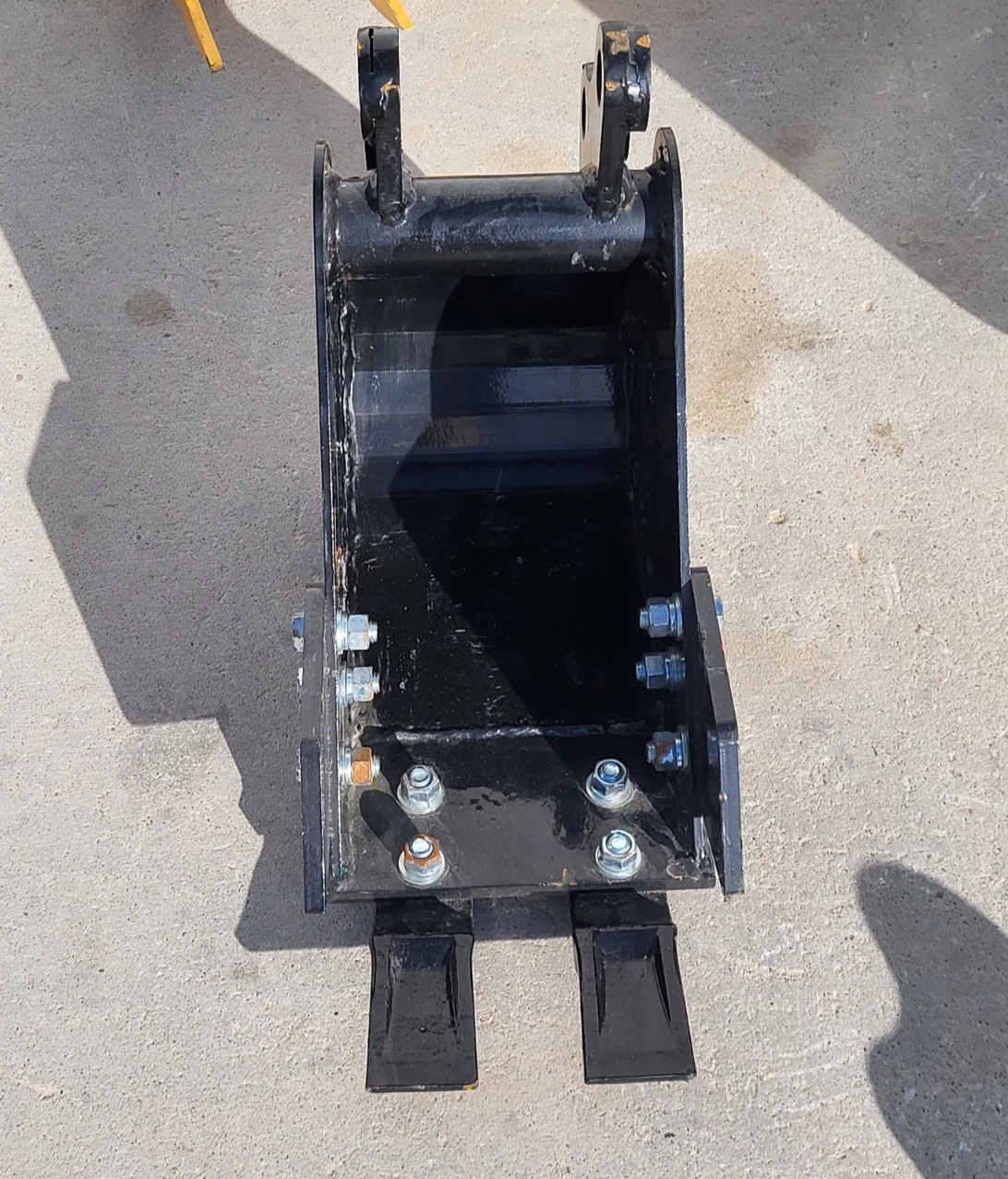 Black 8-inch trenching bucket from above, two digging teeth and a bolt-on pin hitch