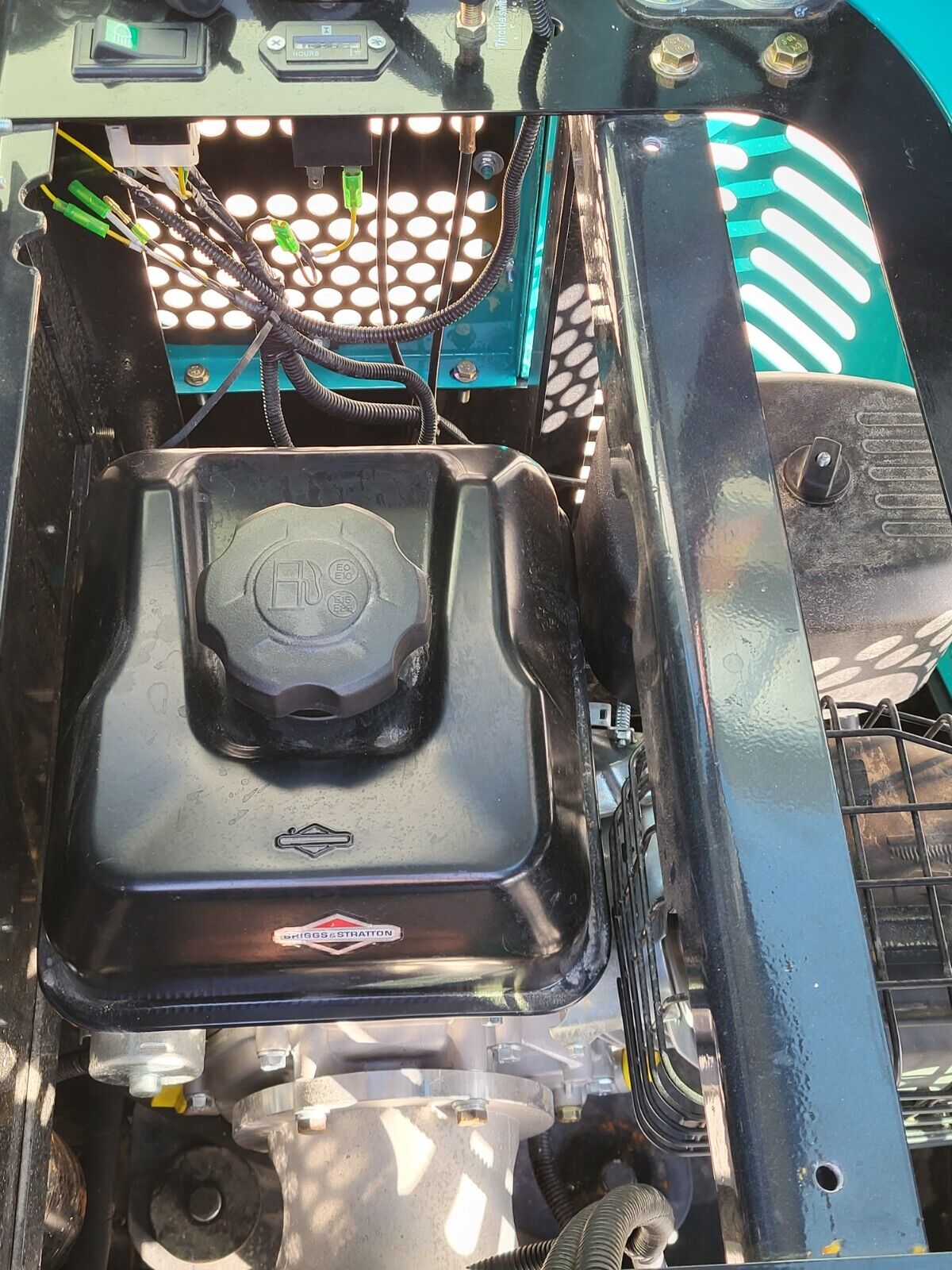 FF13 engine bay: Briggs & Stratton gasoline engine, black fuel tank and cap, wiring harness under the raised hood