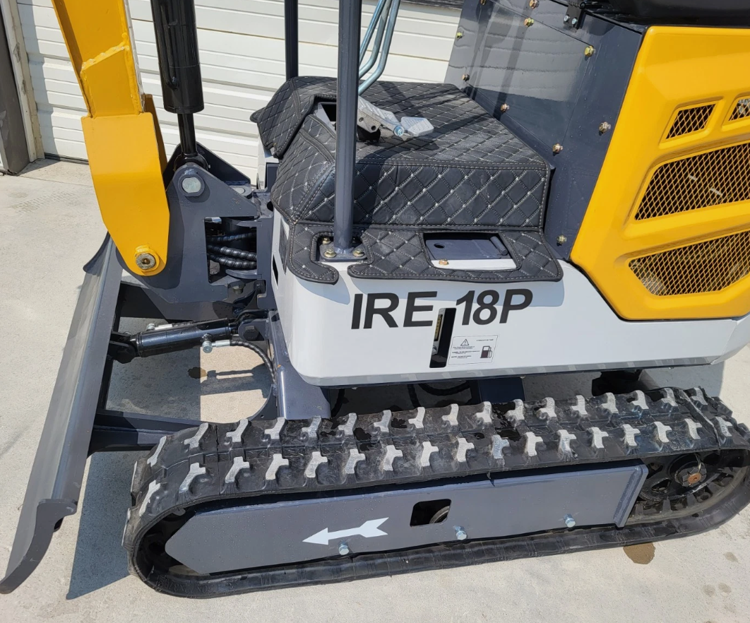 IRE18P mini excavator with quilted seat, yellow and white body, dozer blade and rubber tracks