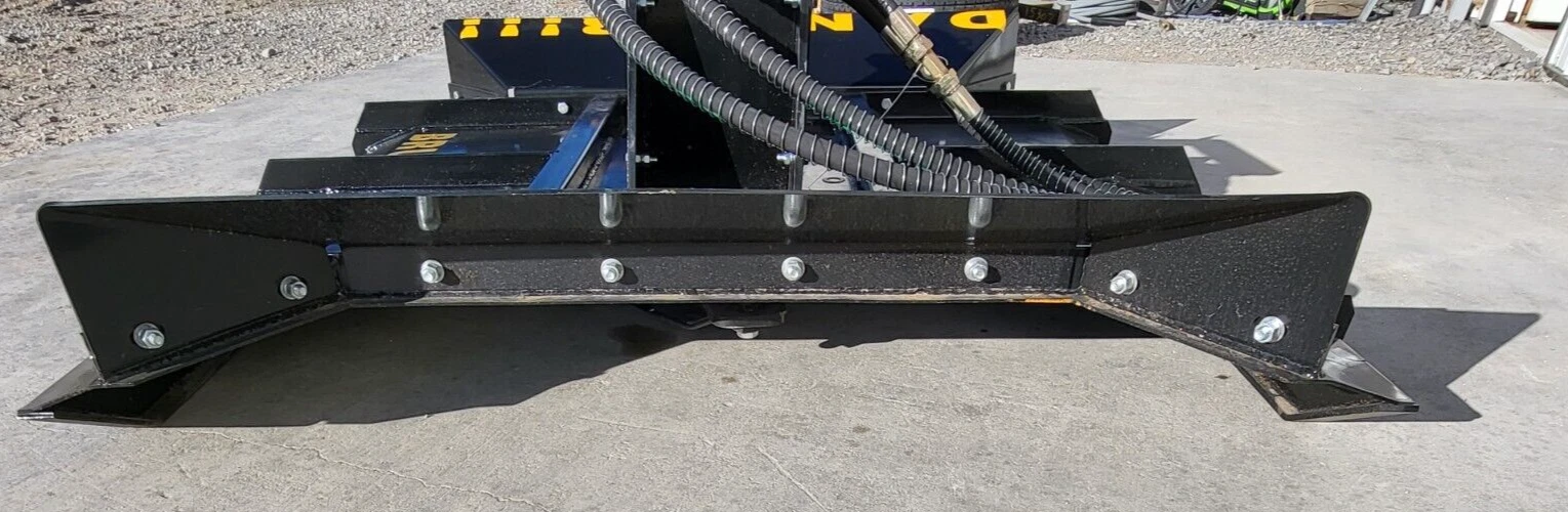 Front of the brush cutter deck: bolted steel skirt and swept-back side plates