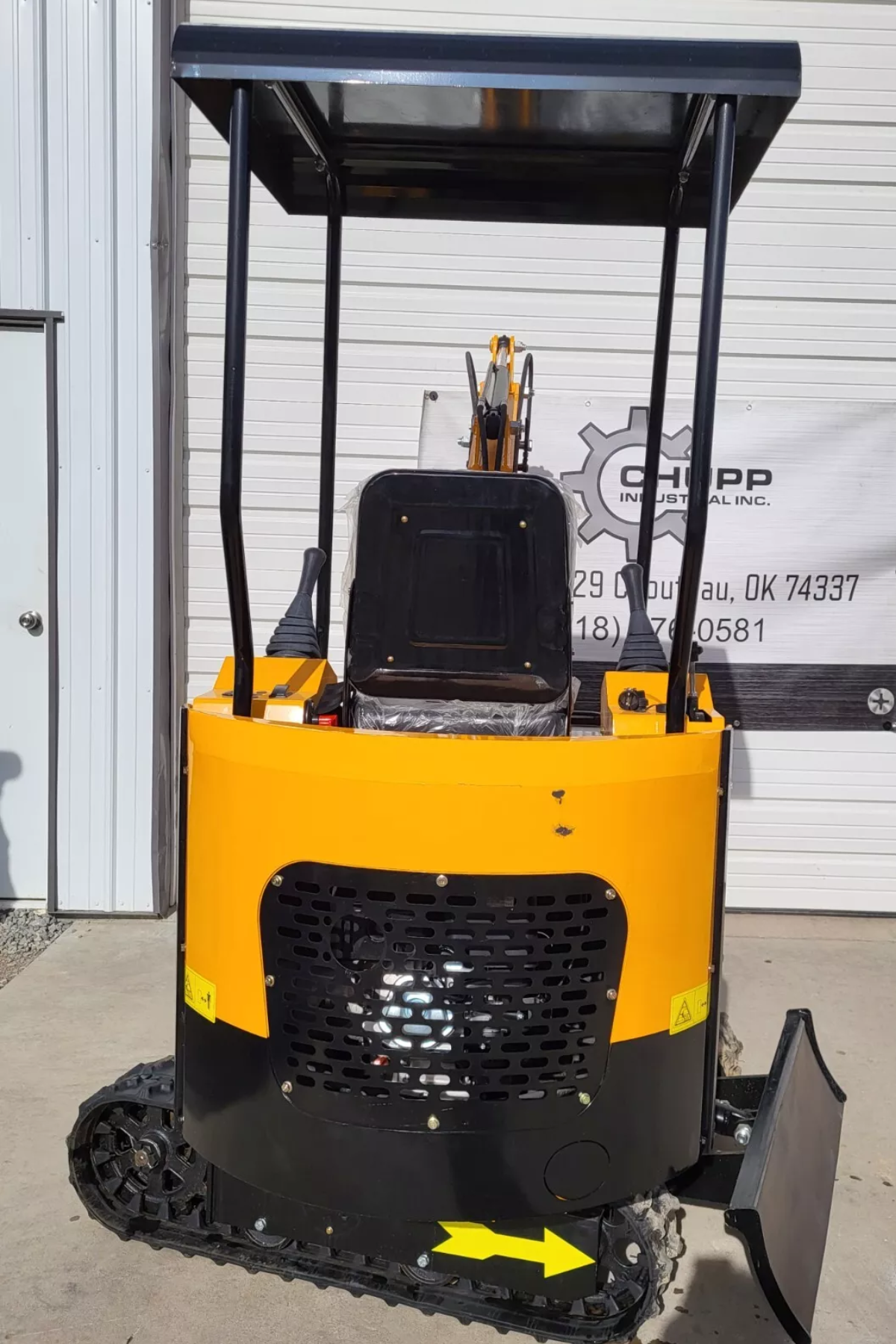 Yellow MIVA VA15 mini excavator from behind: black canopy over the seat and joysticks, engine grille, rubber tracks