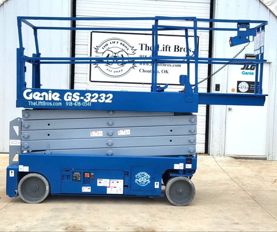 Blue Genie GS-3232 electric scissor lift, platform lowered, guardrails up, extension deck and solid cushion tires