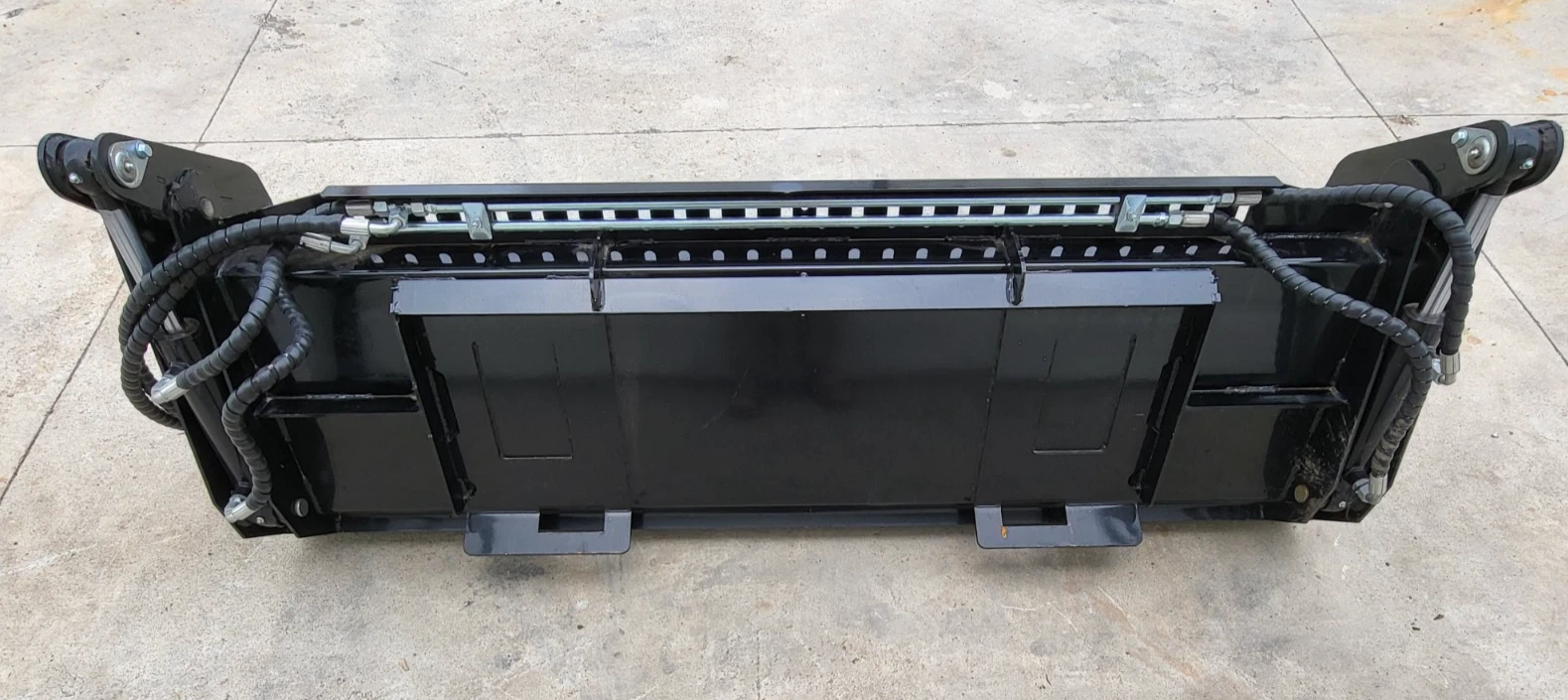 72-inch 4-in-1 bucket from the back: universal quick-attach plate, cylinders and sleeved hose runs