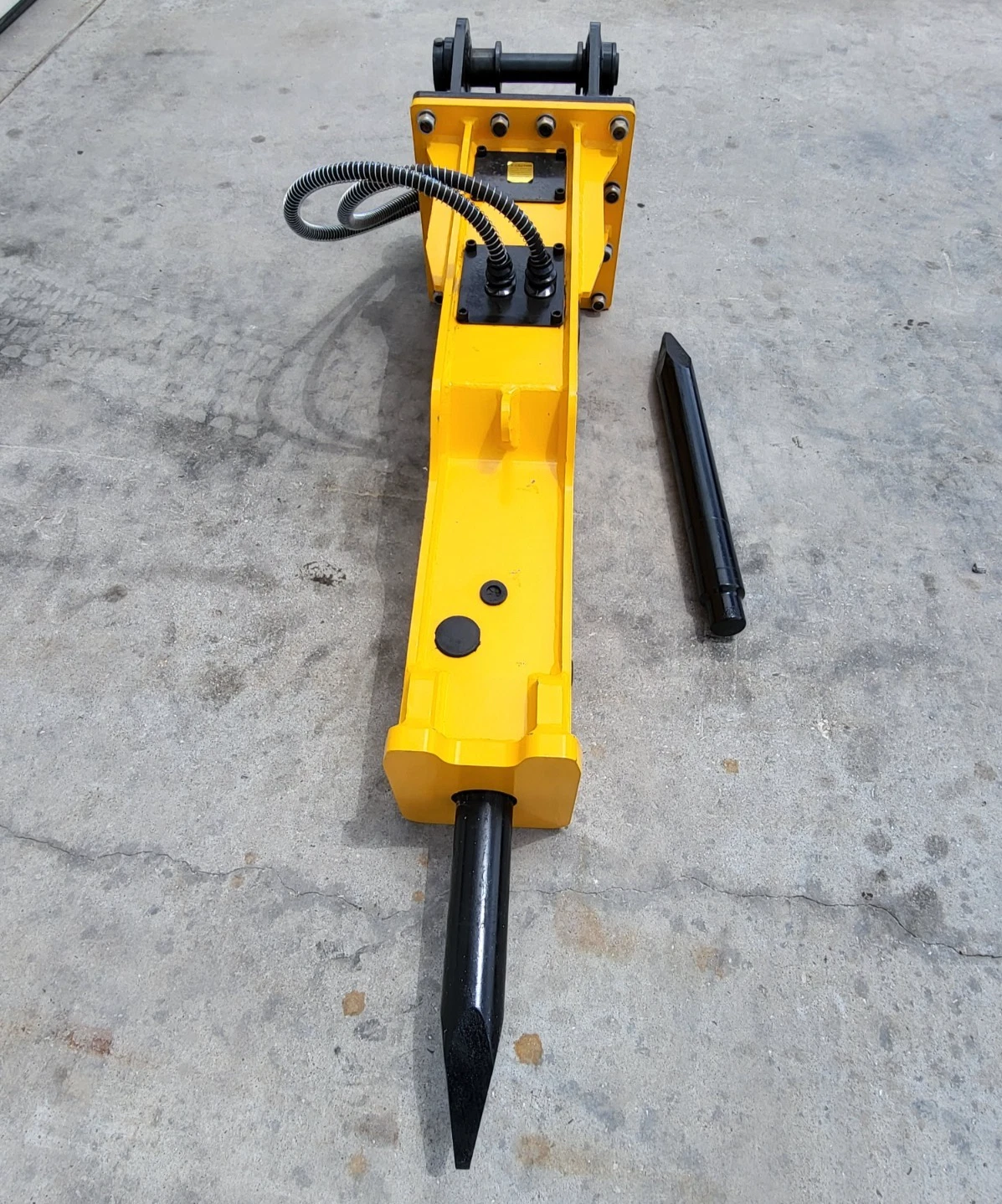 TOFT750 breaker viewed down its length, moil chisel fitted and a spare chisel lying alongside