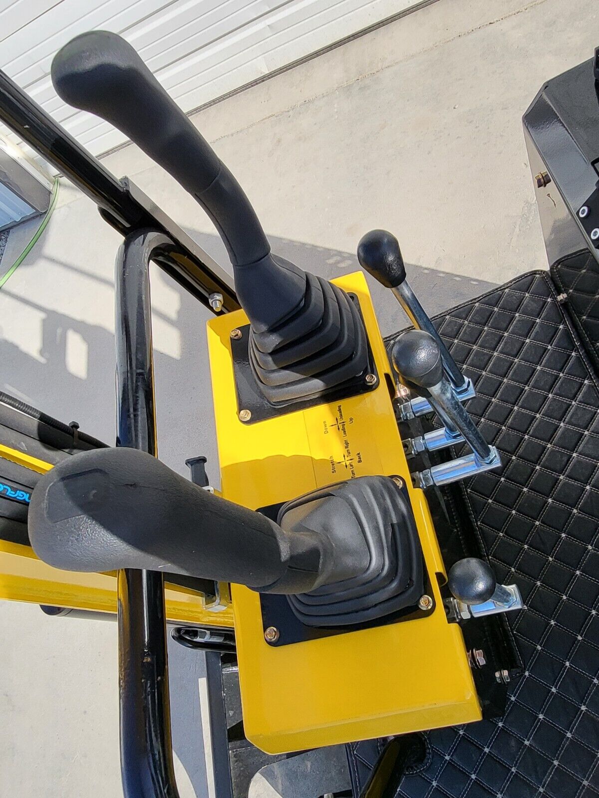 AGT QH12R controls: two boot-sealed joysticks on the yellow console with travel levers and control decal