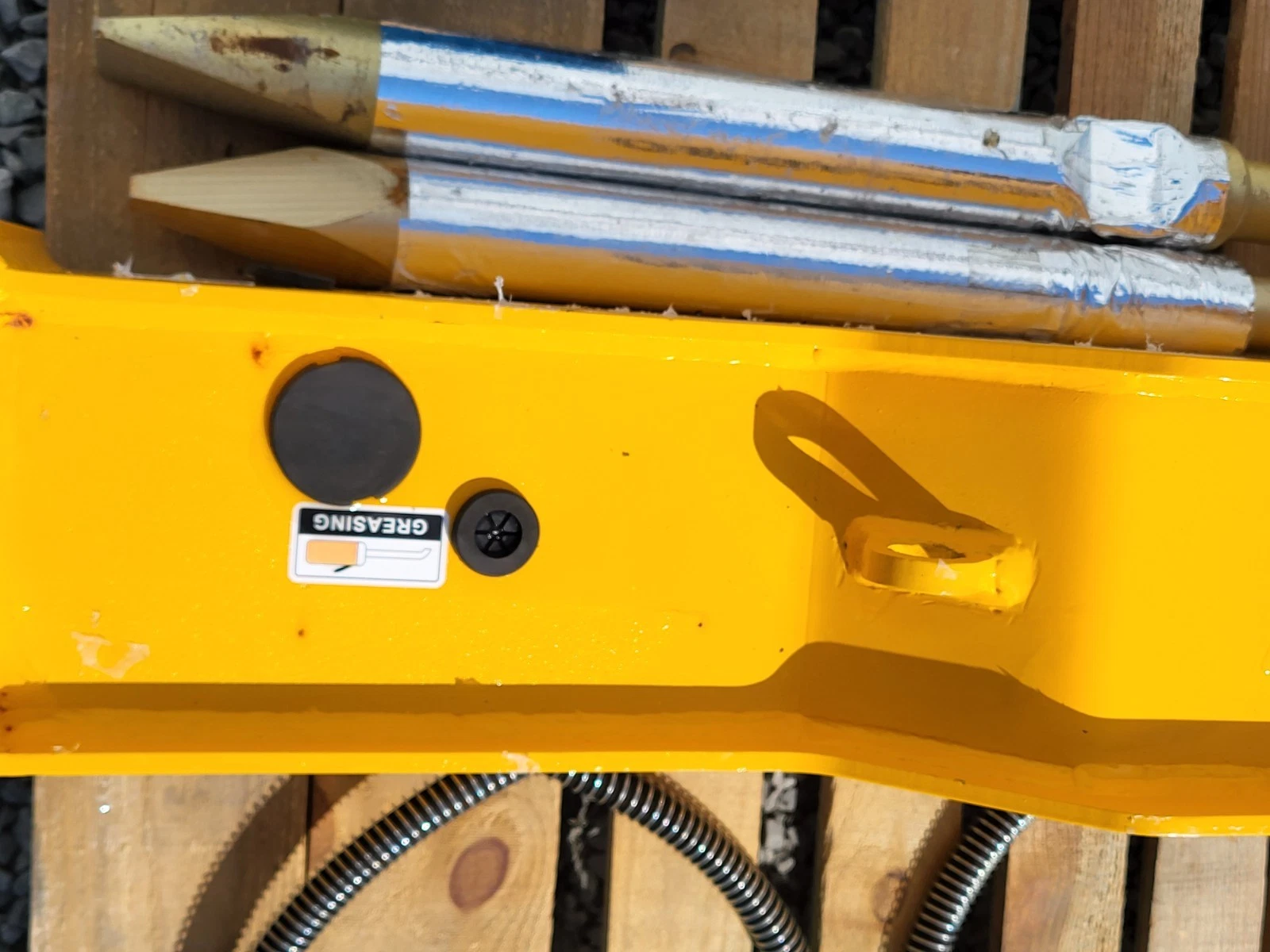 GREASING decal, grease fitting and lifting eye on the SDCH680's yellow body, two wrapped chisels above