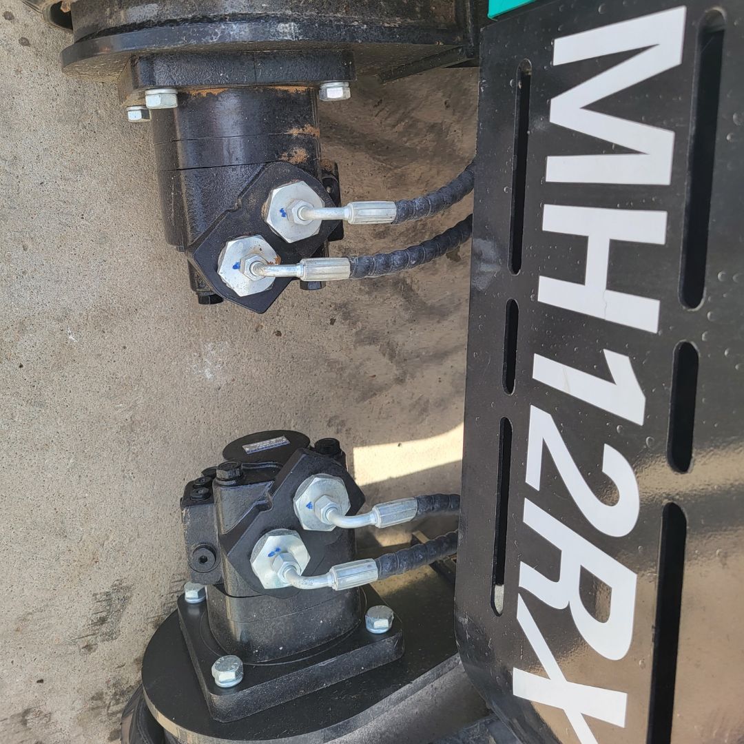Hydraulic drive motors on the AGT MH12RX undercarriage with steel hard lines and quick-connect hoses