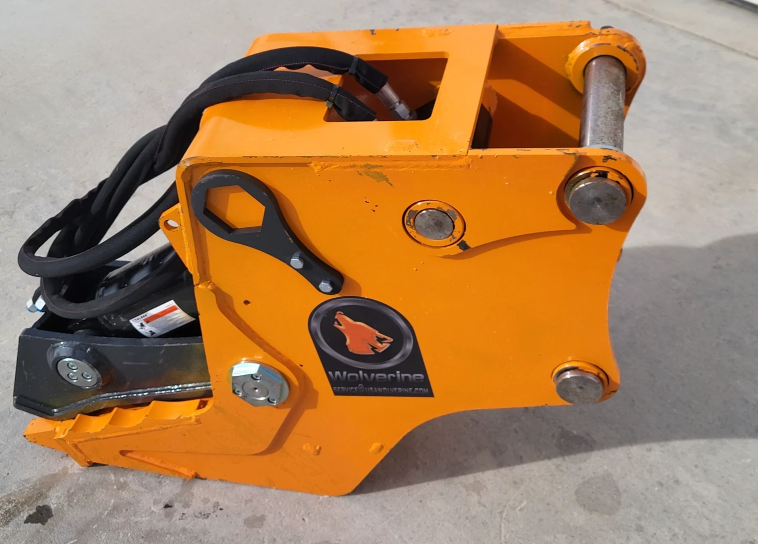 Orange Wolverine attachment head with mounting pins, coiled hoses and the Wolverine decal