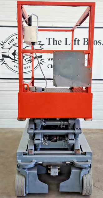 Skyjack S3219 end view, red platform lowered with mounted control box, gray scissor stack and chassis