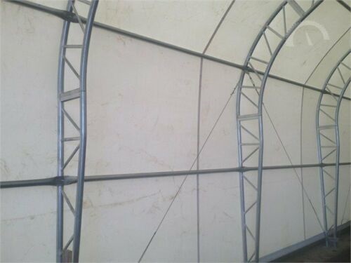 Galvanized steel dual truss arches and purlins seen inside the fabric building, supporting the white PVC cover