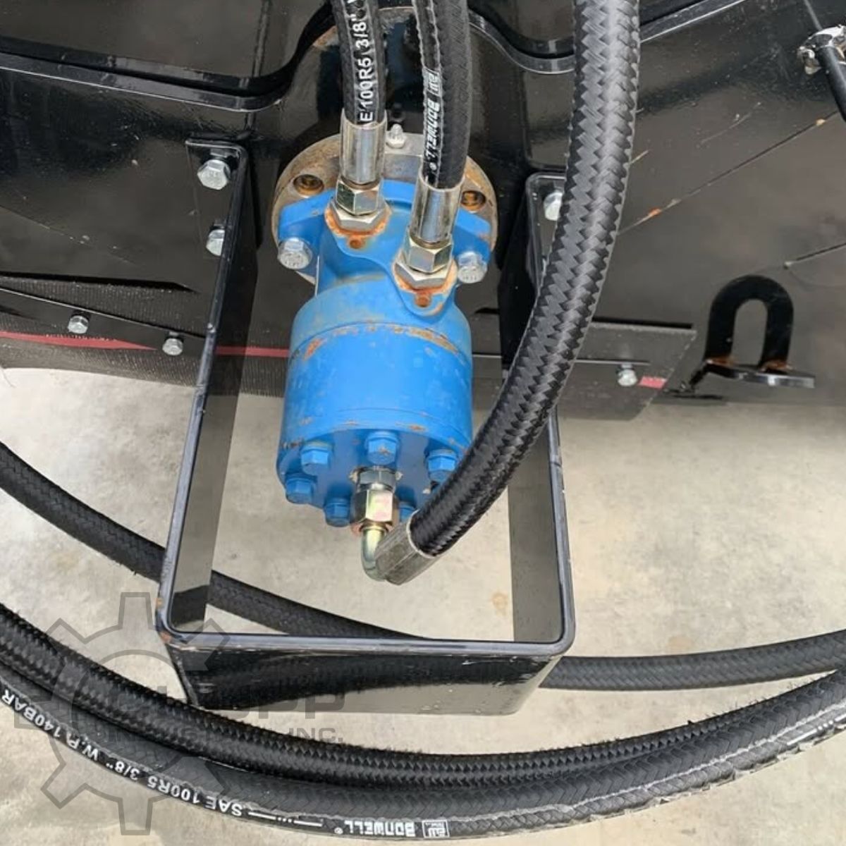 Mower King box broom's blue hydraulic drive motor and braided hoses on the black steel frame