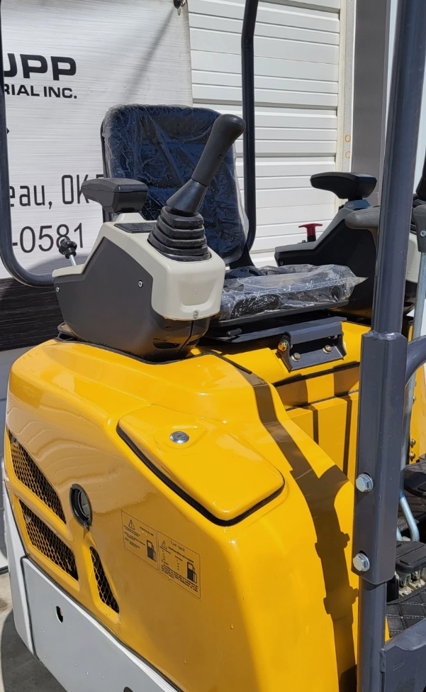 SDLE20 mini excavator pilot joystick and armrest console beside the wrapped seat, above the yellow engine cowl