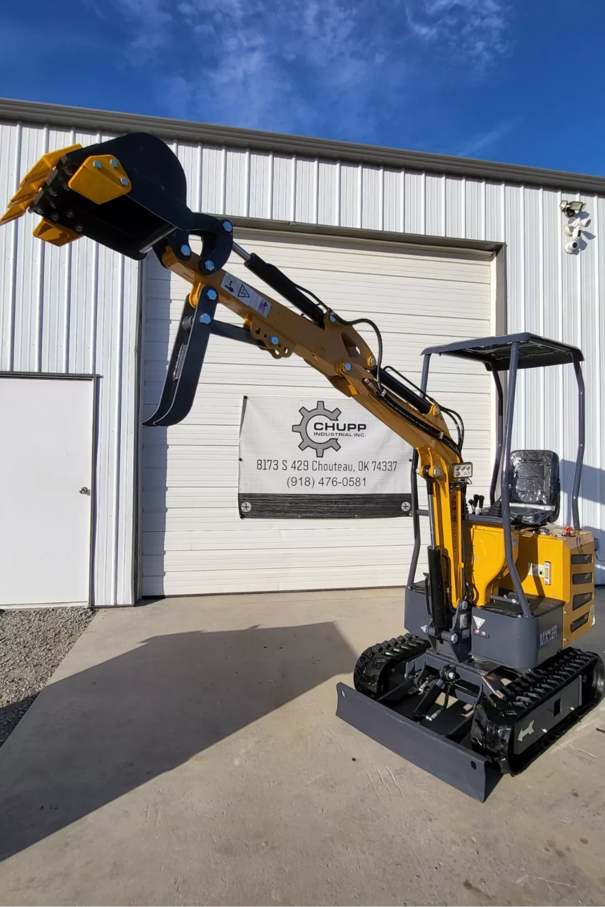 AGT MX12R mini excavator with the boom raised to full height, bucket curled and fixed thumb, canopy and backfill blade