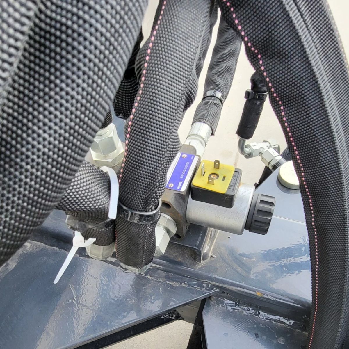Wolverine 6-way dozer blade hydraulics: 12V solenoid control valve and sleeved hoses on the blade frame
