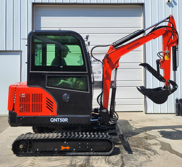 QNT50R mini excavator: enclosed cab, rubber tracks, boom extended with hydraulic thumb and toothed bucket