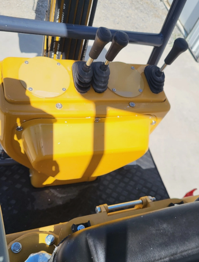 Four booted hand levers on the MX12RX mini excavator control stand, above the rubber floor mat and the seat
