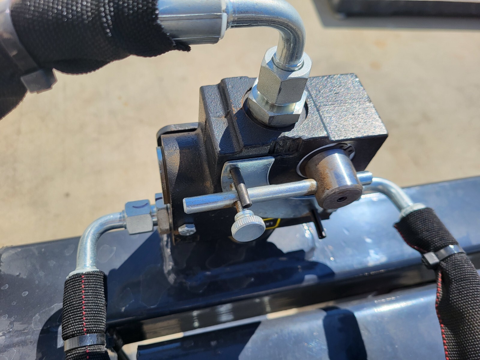 Skid steer quick-attach pin coupling assembly.