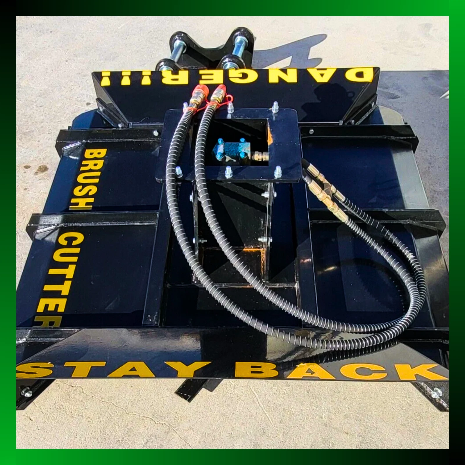 Brush cutter deck from above: hydraulic valve, sheathed hoses and yellow DANGER and BRUSH CUTTER lettering