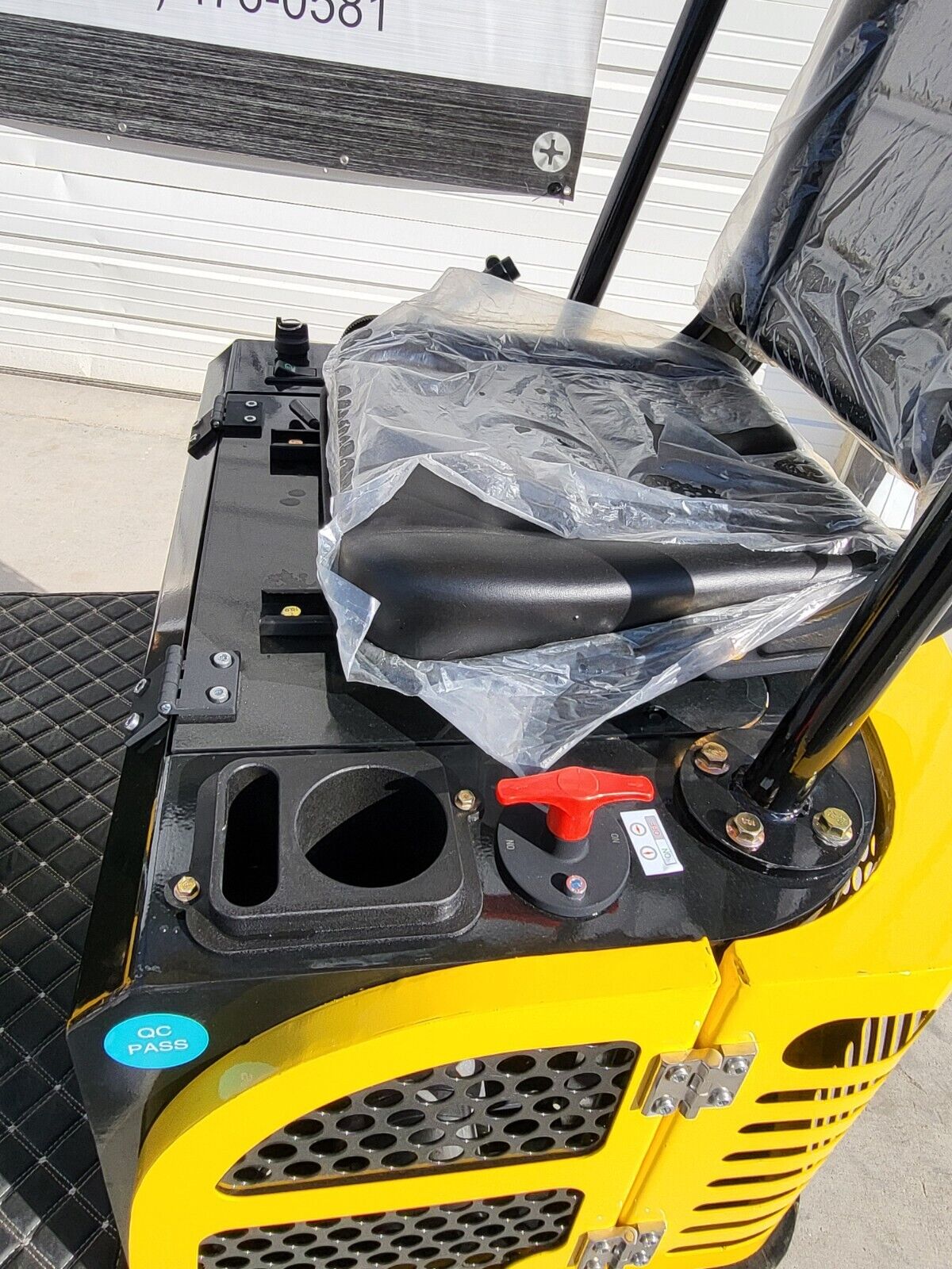 AGT QH12R rear deck: red battery disconnect switch, tray and factory-wrapped seat over the vented engine cover