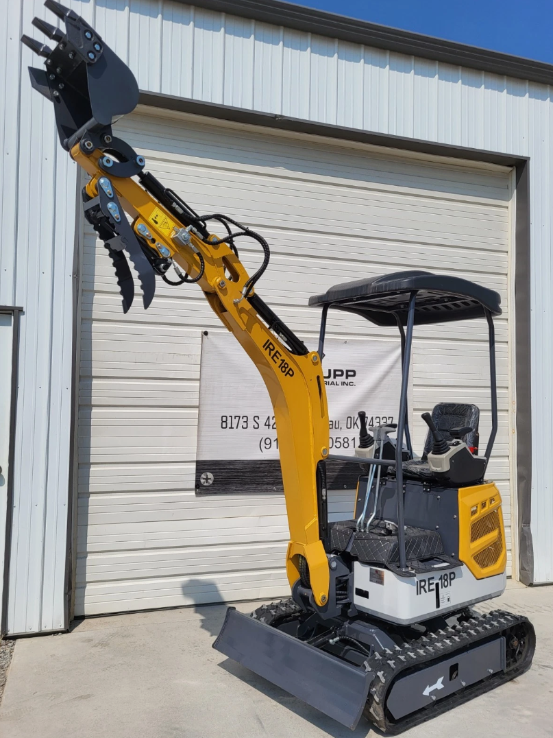 IRE18P mini excavator with boom raised high, toothed bucket and open hydraulic thumb above the dozer blade