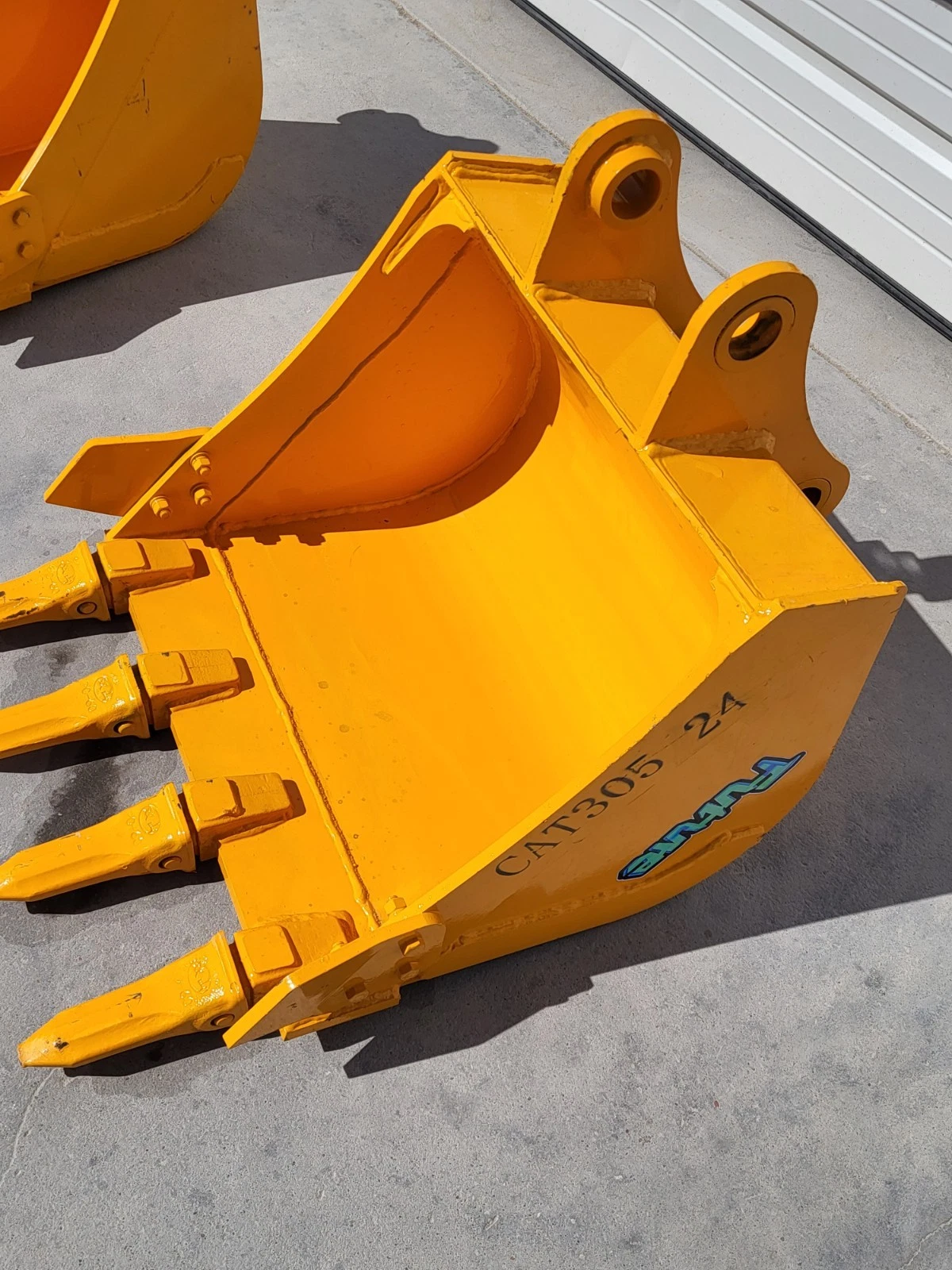 Yellow excavator bucket stamped CAT305 24 with a Future decal, four bolt-on teeth and twin pin bosses
