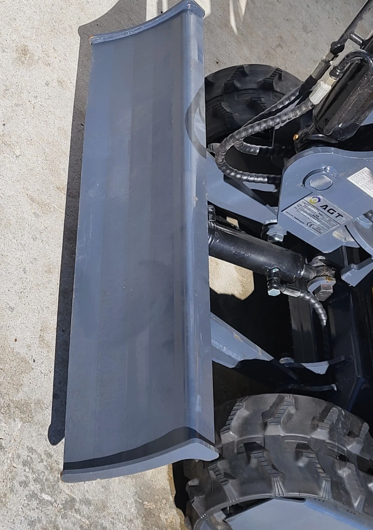 QK18RXS-C backfill blade: curved gray dozer blade on its hydraulic cylinder, ahead of the rubber tracks