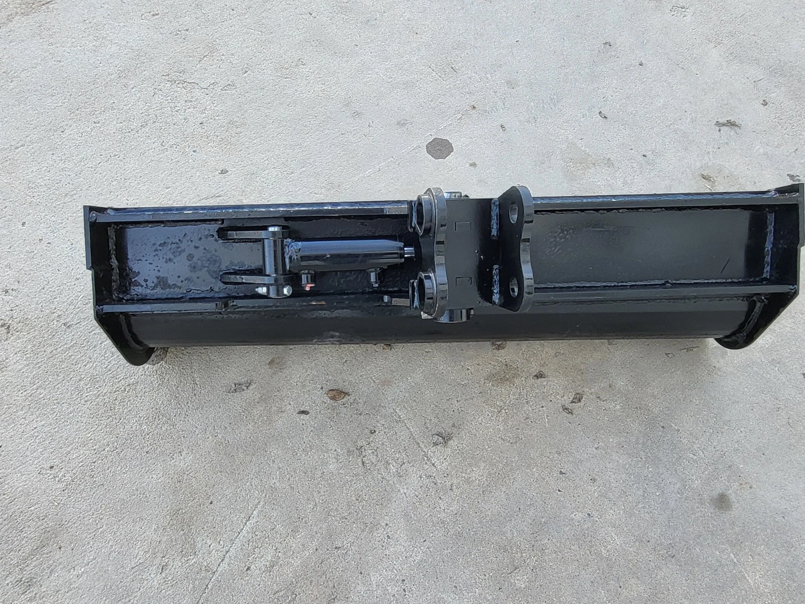 Back of the 40-inch tilt bucket: hydraulic tilt cylinder, center pivot and bolt-on twin-pin bracket