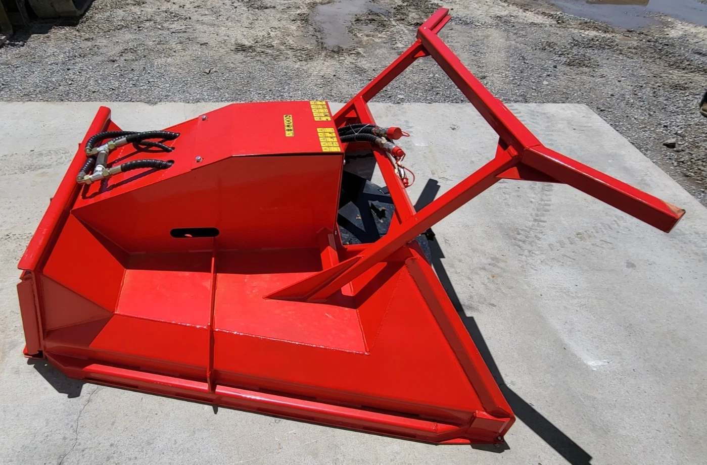Red disc mulcher from above: sloped housing, twin hydraulic hoses with couplers and the steel push frame