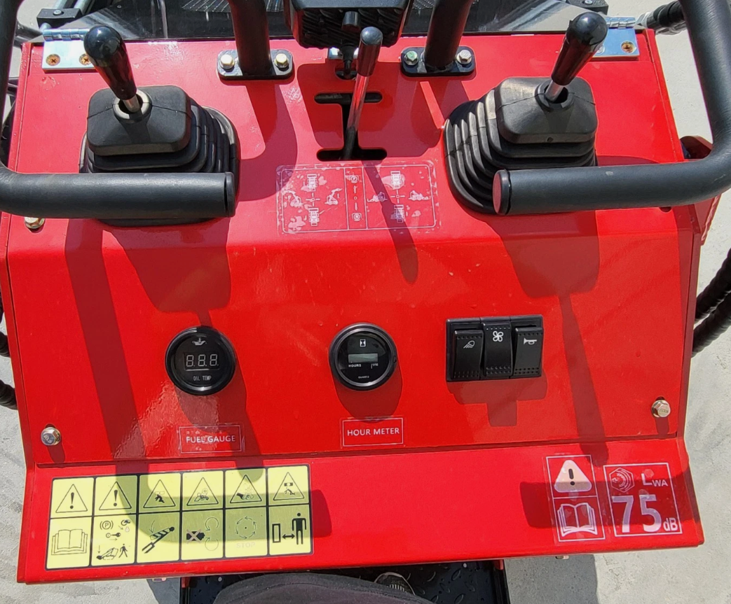 Control console of the red mini skid steer: twin joysticks, fuel gauge, hour meter and rocker switches
