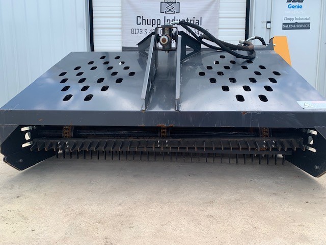 Gray hydraulic landscape rake, slotted debris hopper deck over a tined raking drum, hydraulic hoses at the mount