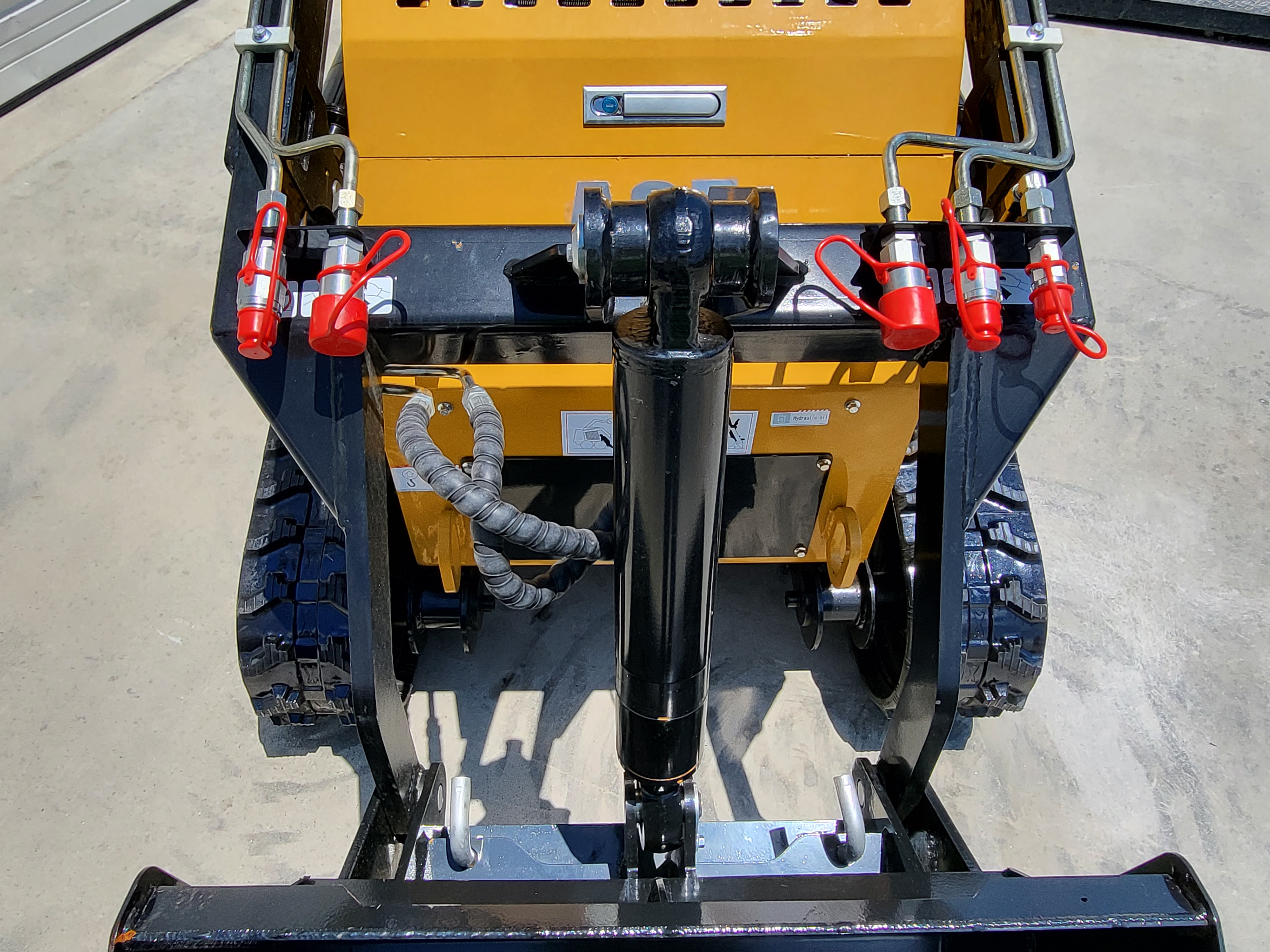 AGT CRT23 front: universal quick-attach plate, tilt cylinder and red-capped auxiliary hydraulic couplers