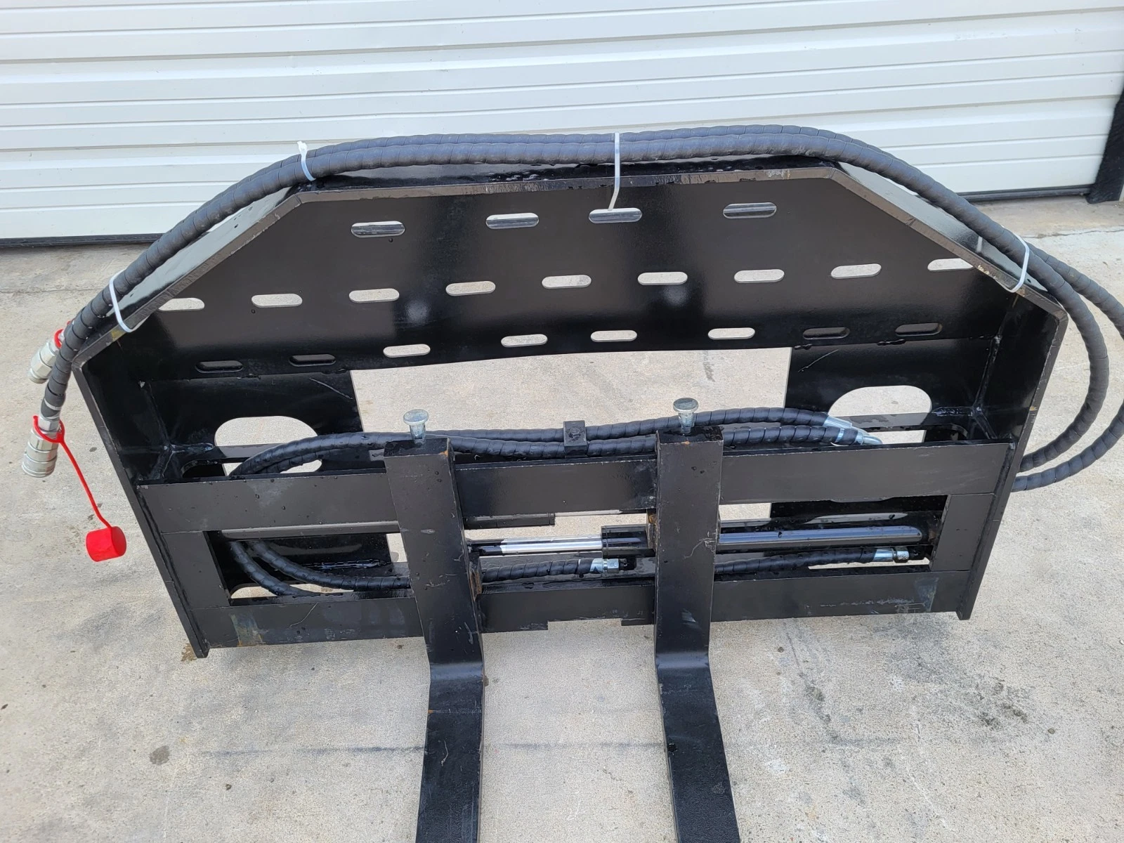 60-inch hydraulic pallet forks at an angle, slotted backrest, red-capped couplers and hose run