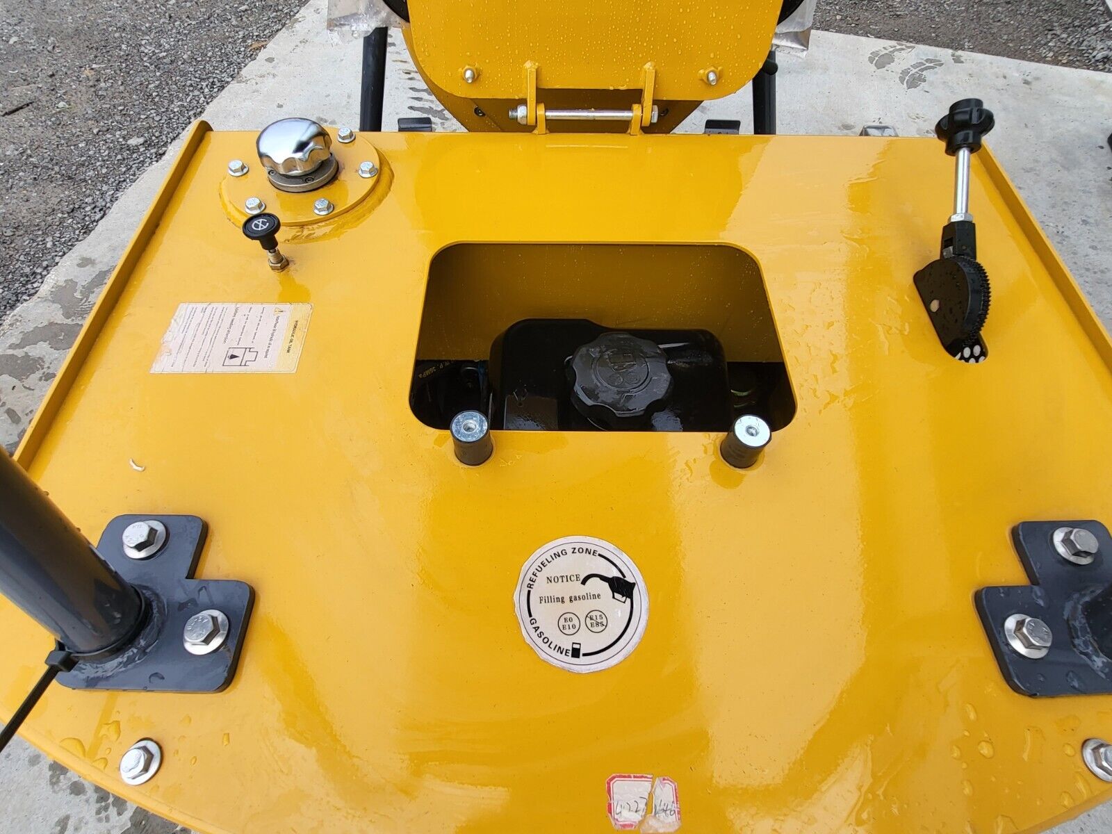 DM12-C rear deck: chrome hydraulic fill cap, recessed gasoline fill cap with the refueling decal, and the throttle lever