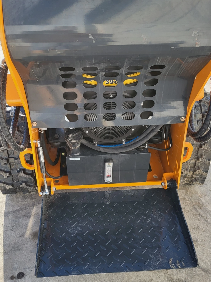 ATS-T460 mini skid steer from the rear: vented engine cover, cooling fan, hydraulic tank sight gauge, stand-on platform