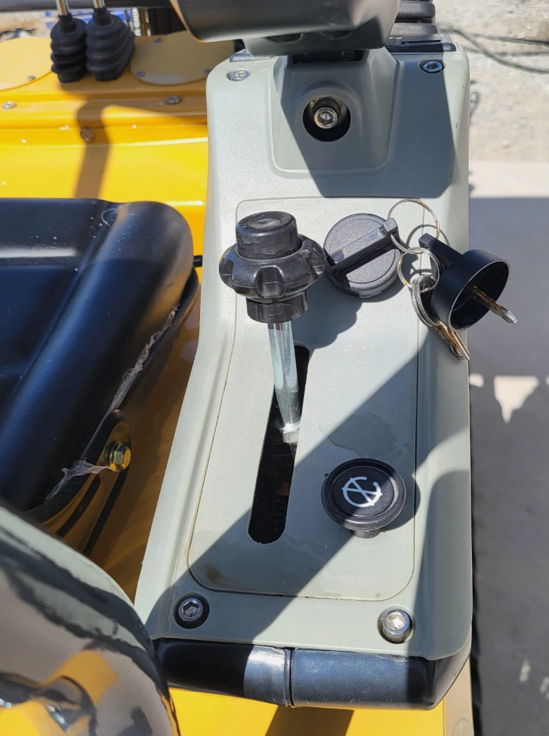 MX12RX mini excavator side console: throttle lever, keyed ignition with the keys in it, and a push-button switch