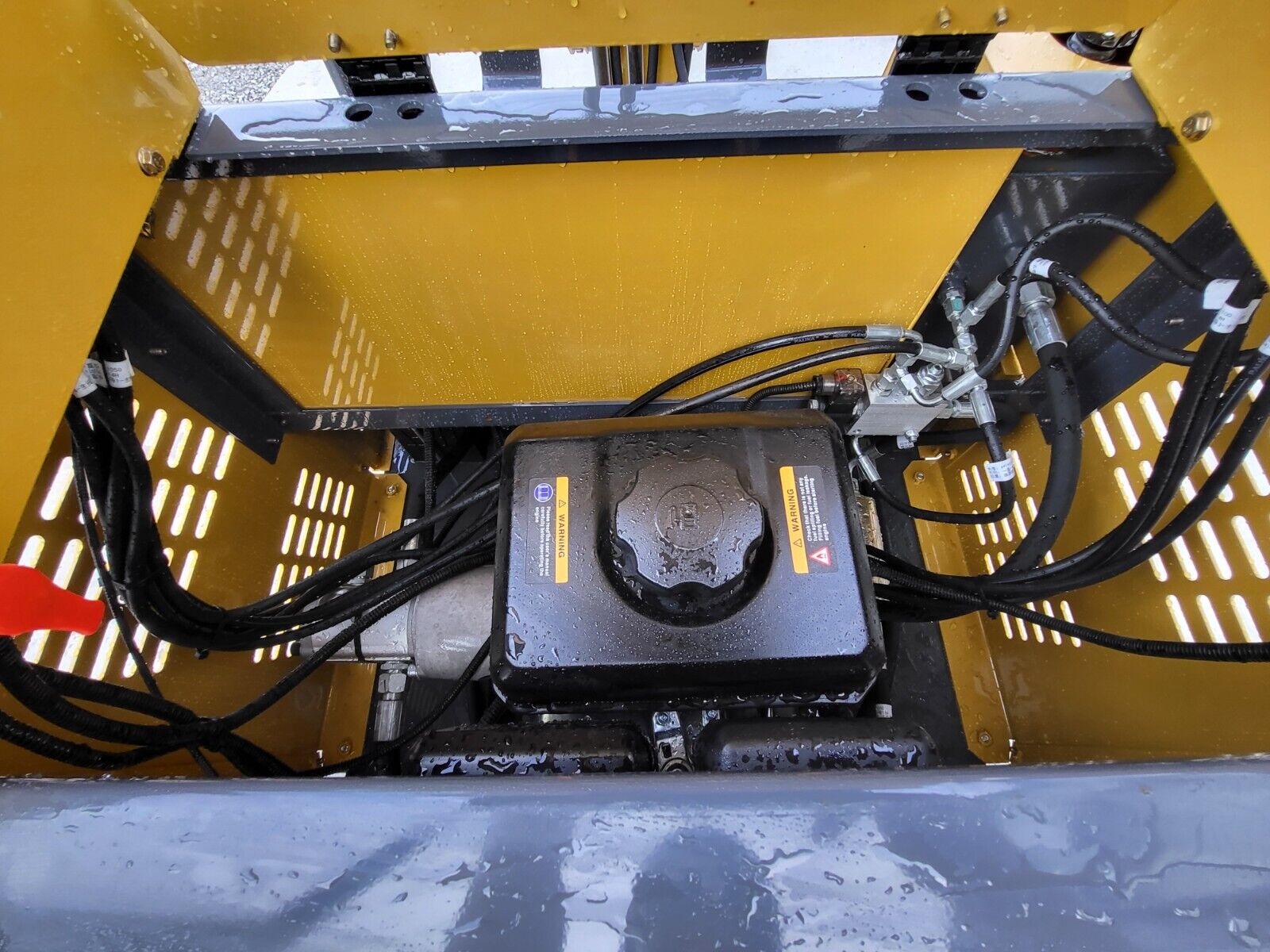 AGT H15 engine bay: black fuel tank with filler cap, hydraulic lines and fittings inside the yellow shroud