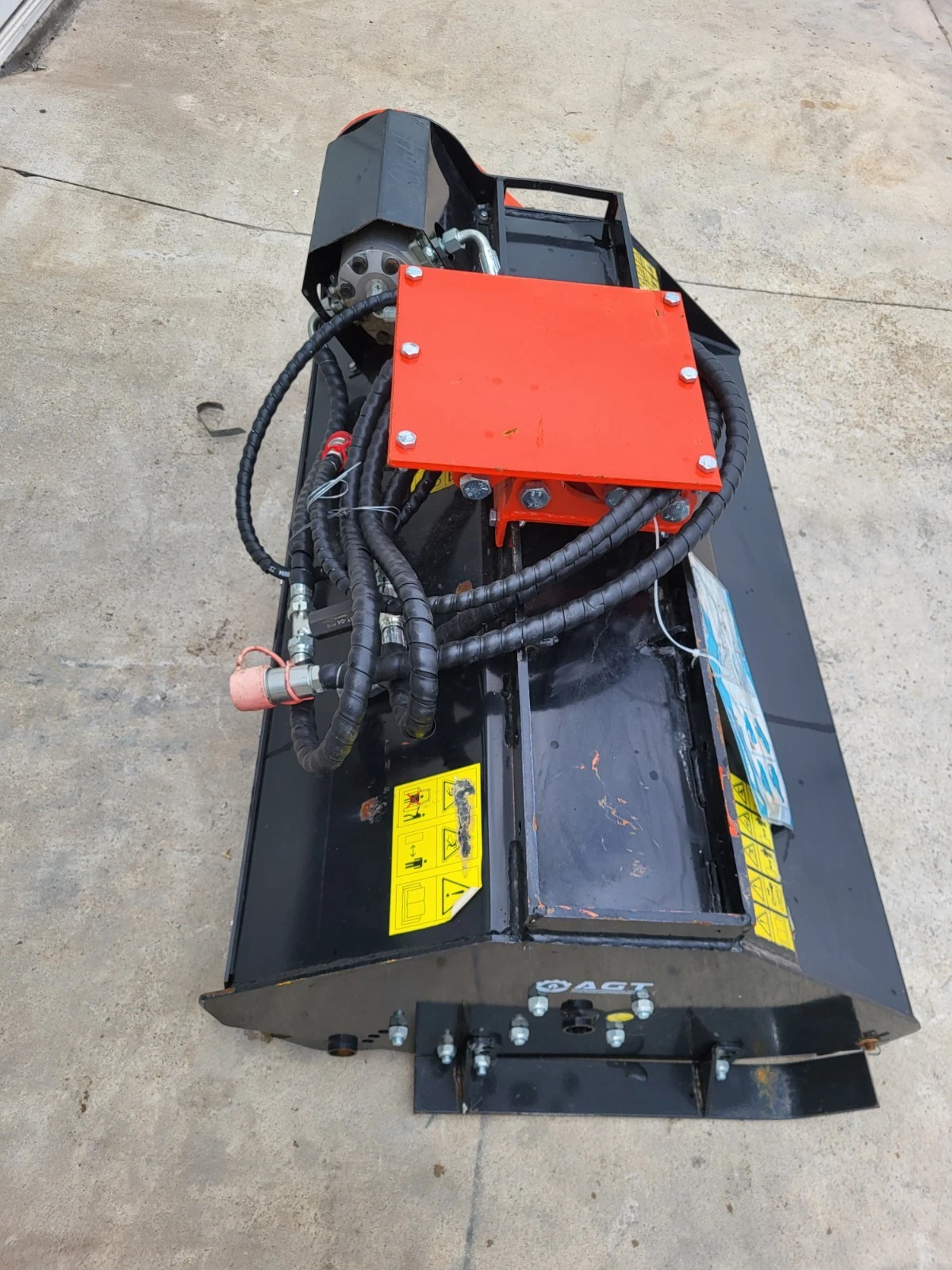 Flail mower with its mounting bracket and AGT deck plate, coiled hoses and capped quick couplers