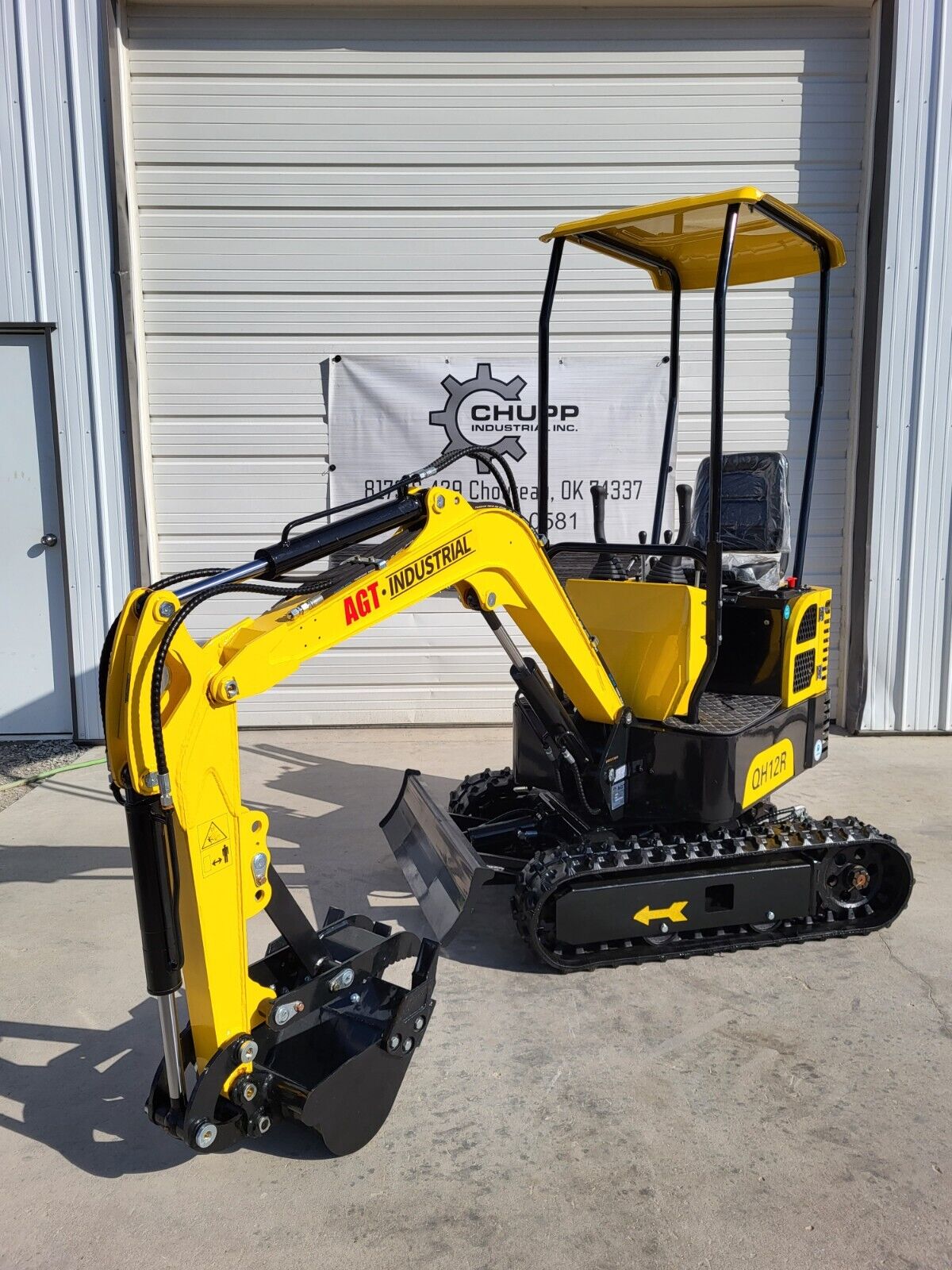 Yellow AGT QH12R mini excavator with canopy, digging bucket and thumb, backfill blade and rubber tracks