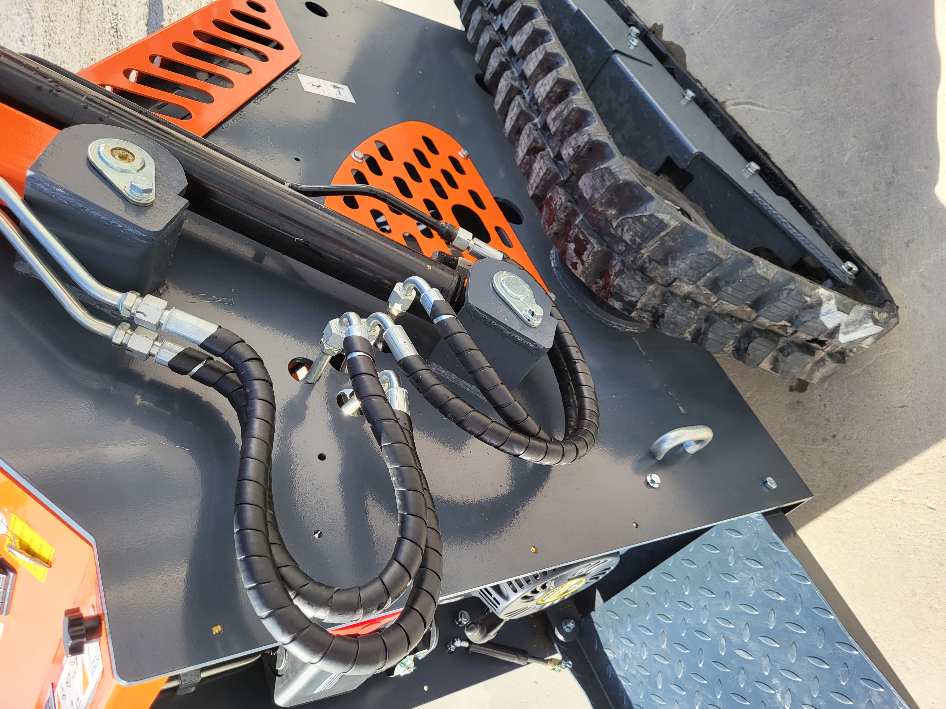 AGT YSRT14 auxiliary hydraulic hoses coiled along the loader arm above the rubber track and diamond-plate platform