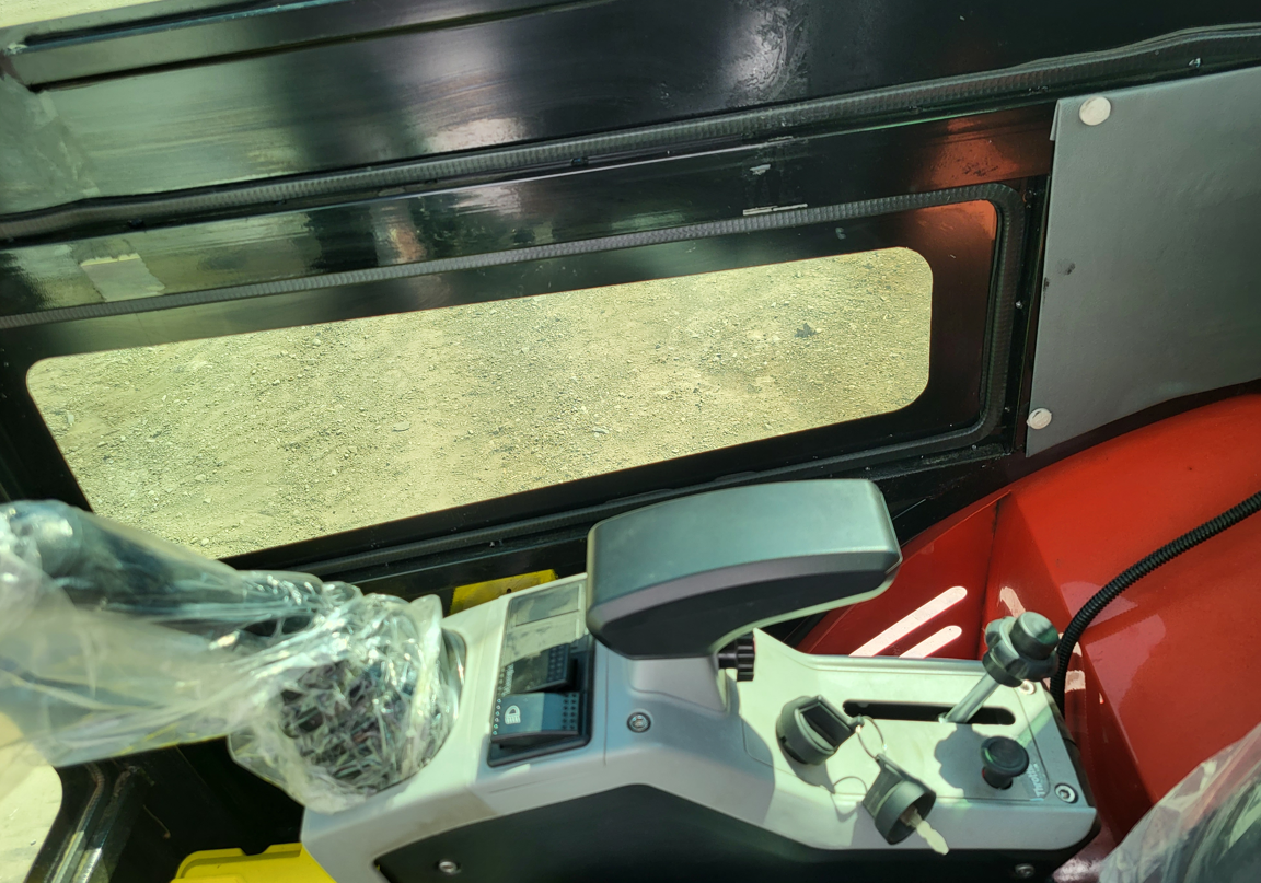 Mini excavator cab: right console with joystick, gauge display and ignition key, still in factory plastic wrap