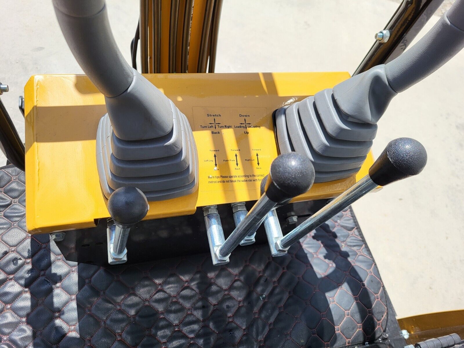 AGT H12R mini excavator control console: two joysticks, four steel hand levers and the operating decal