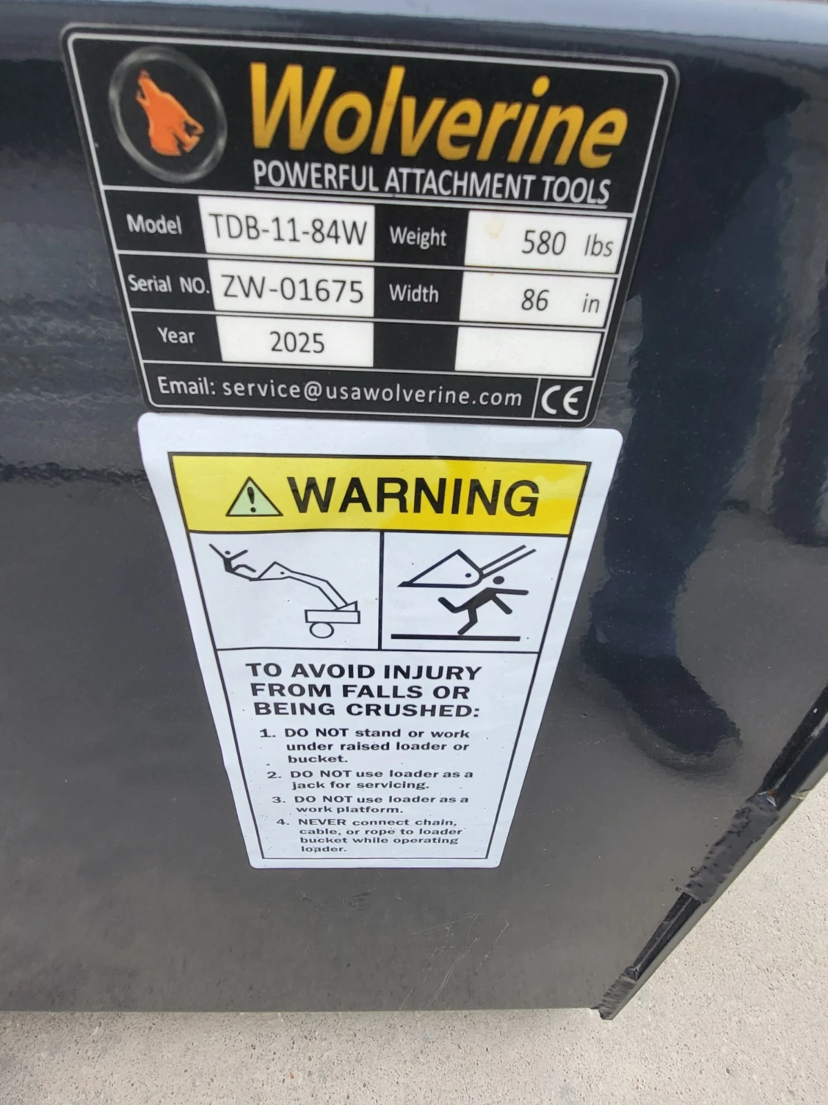 Wolverine data plate: model TDB-11-84W, 580 lbs, 86 in wide, 2025, above a fall and crush warning