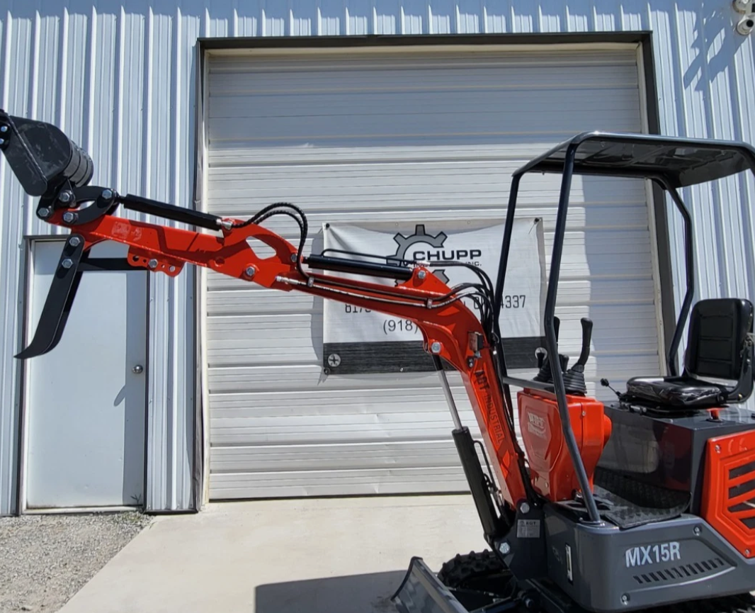 MX15R mini excavator with boom and arm extended and bucket raised, black canopy over the operator seat