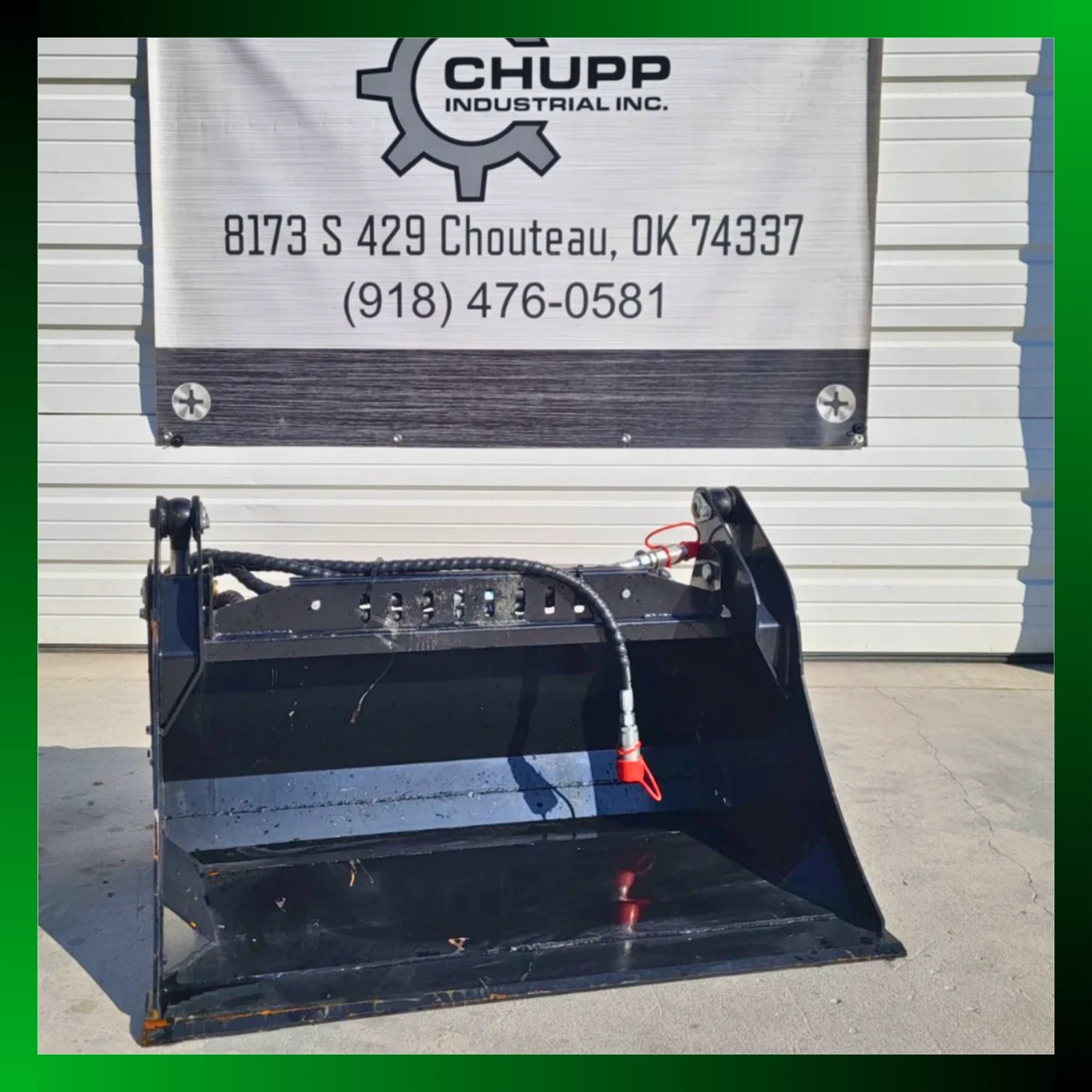 Black 4-in-1 skid steer bucket below the Chupp Industrial banner, hydraulic hose coiled over the top, green border
