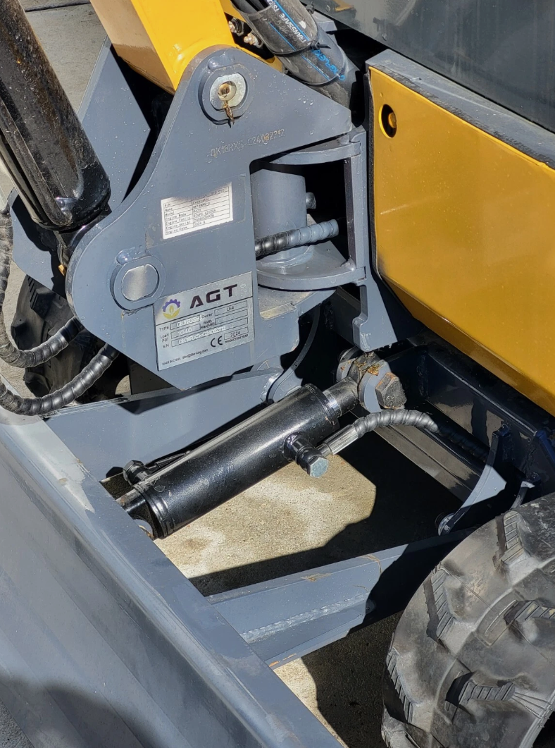 QK18RXS-C swing bracket: AGT data plate, swing cylinder and hydraulic lines above the backfill blade