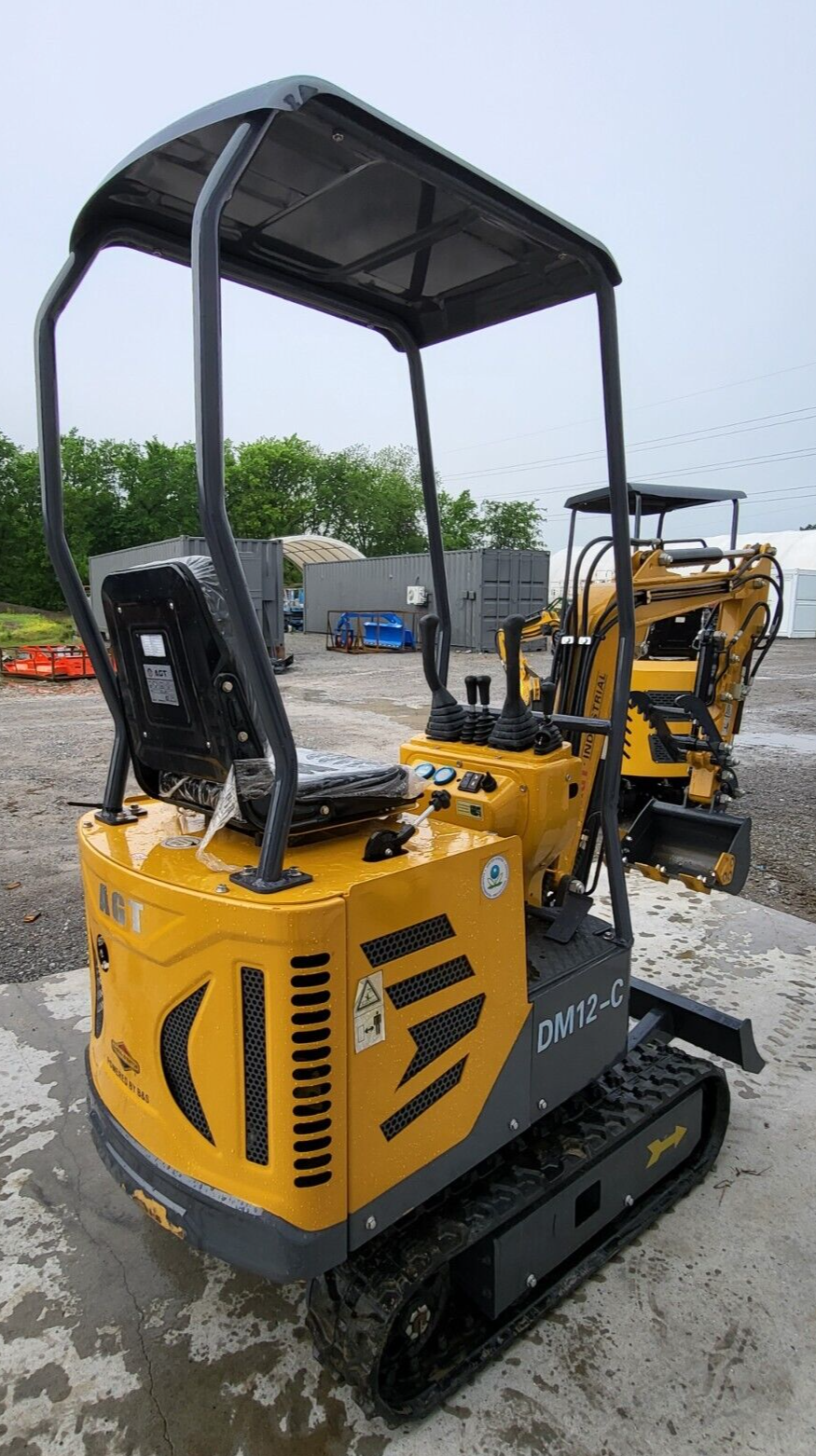 AGT DM12-C mini excavator from behind: vented engine housing with a Powered by B&S decal, canopy, seat and joysticks