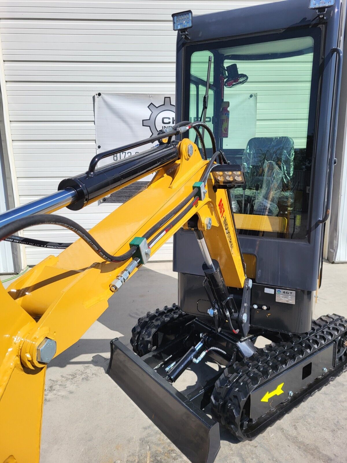 AGT H13R boom with lift cylinder and LED work light in front of the glass cab, dozer blade and tracks below