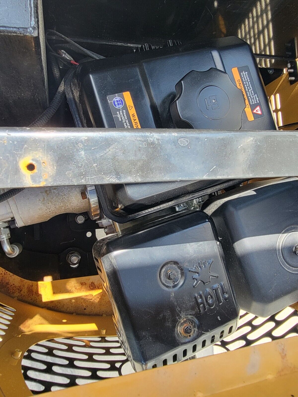 Fuel tank, cap and shielded muffler on the AGT H12R mini excavator engine, with the electric starter alongside