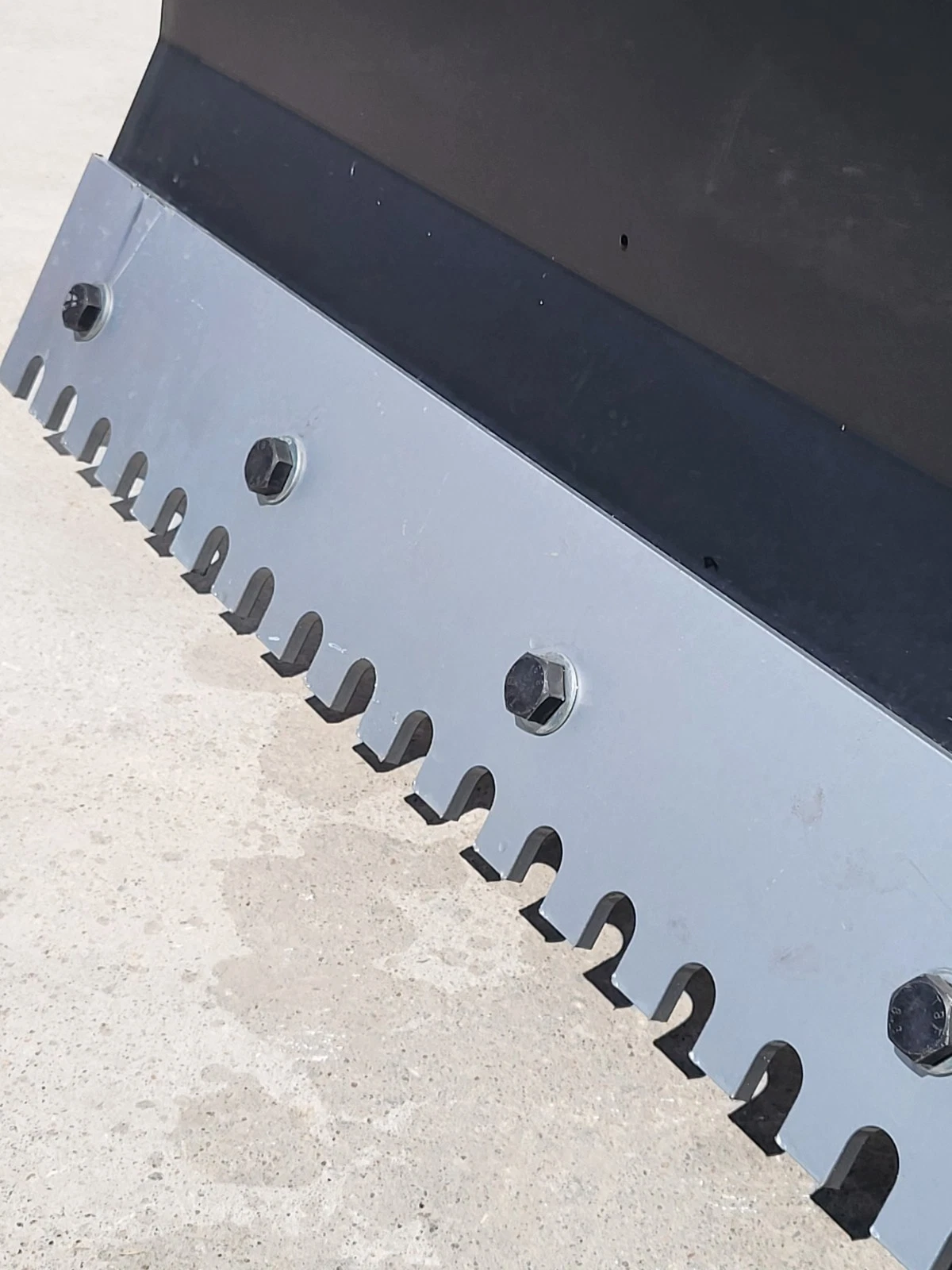 Serrated bolt-on cutting edge of the push blade, mounting bolts and tooth pattern